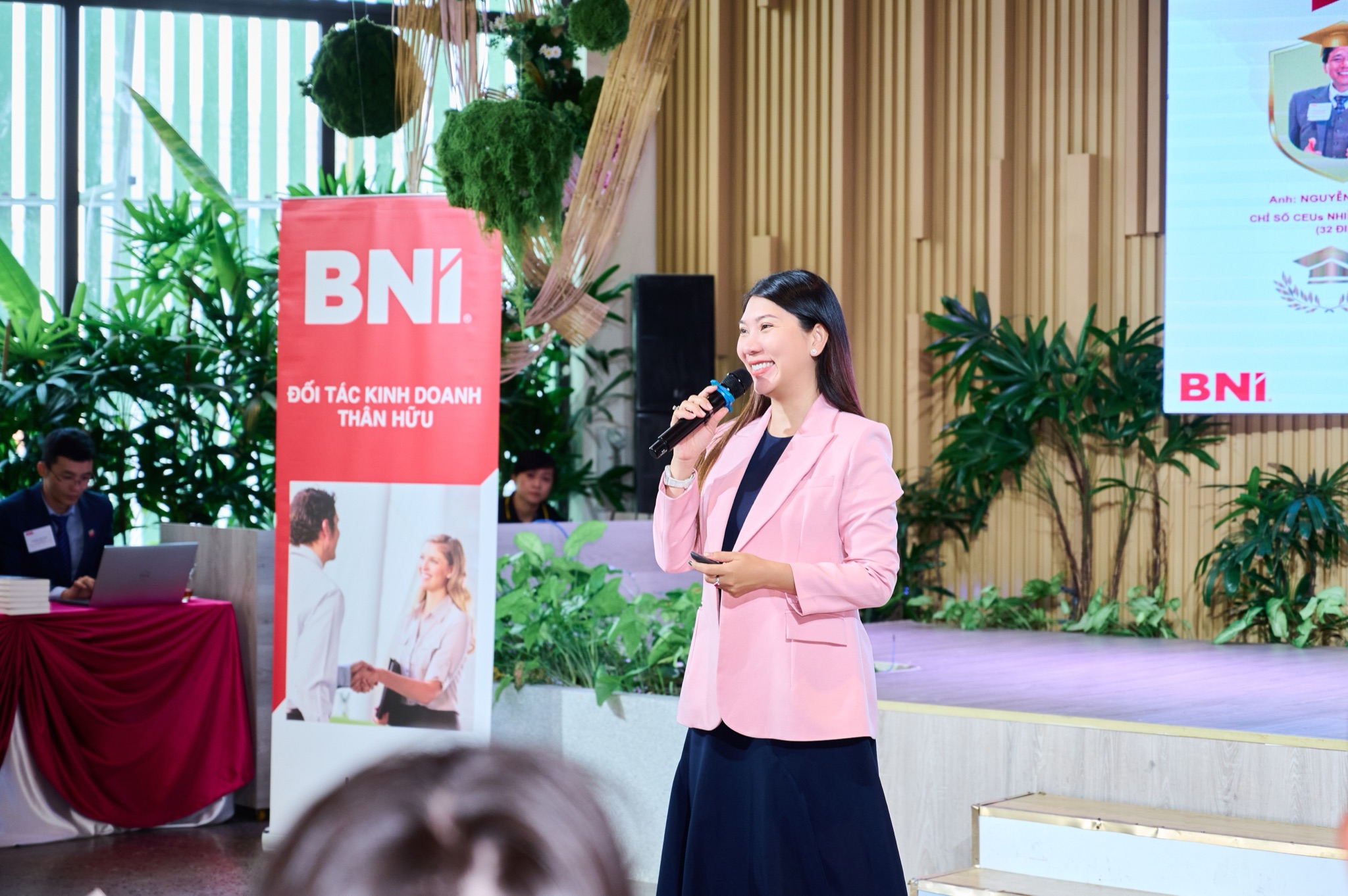 Phương Anh cầm micro chia sẻ trước hội trường doanh nhân